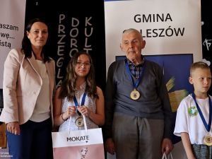 Powiększ obraz: Wójt Sylwia Cieślar z najmłodszymi zawodnikami i najstarszym szachistą